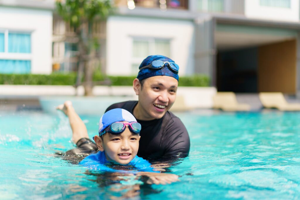 Happy,Cheerful,Asian,Father,And,Son,Playing,And,Swimming,Together