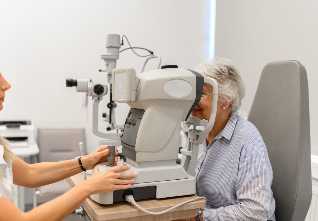 Hands,Of,Female,Optometrist,Examining,Senior,Woman's,Eyes,With,Slit
