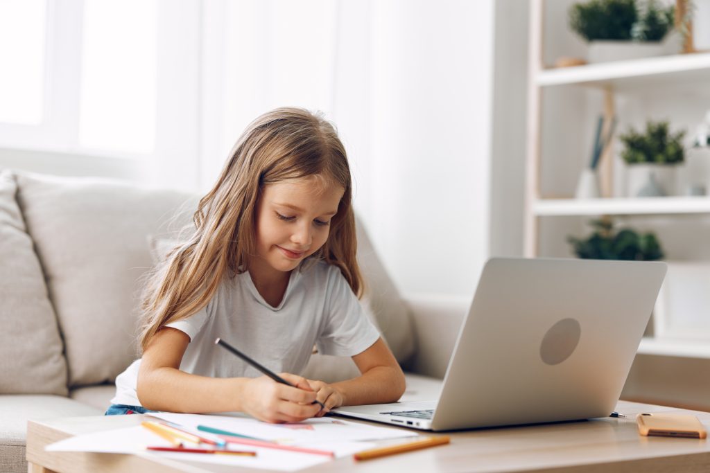 Young,Girl,Sitting,On,Couch,With,Laptop,And,Pencil,,Engaged