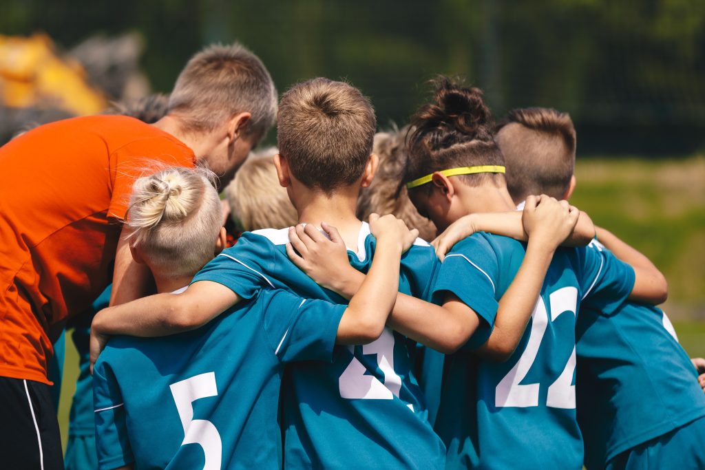 Youth,Soccer,Team,Huddle,With,Coach;,Kids,In,Training,Unity